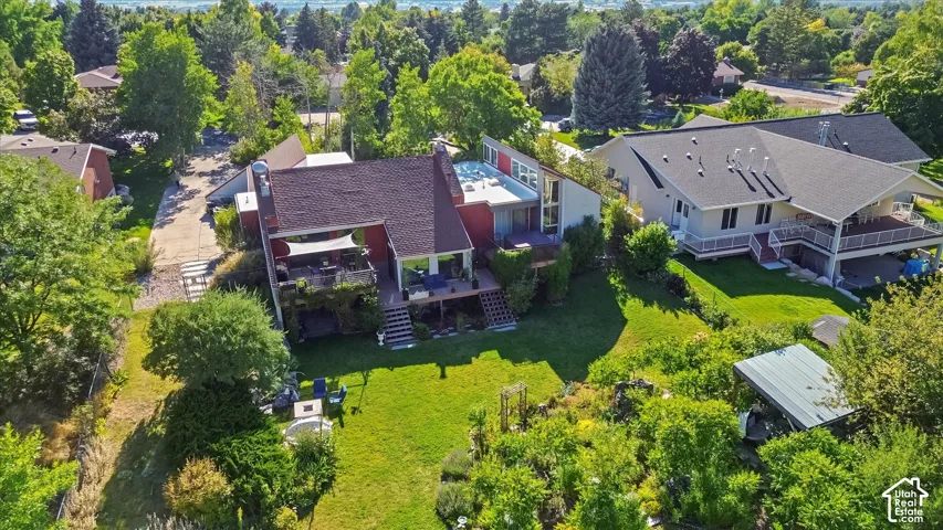 Expansive property featuring a multi-level structure with a tiered deck, a covered patio, and a sloped lawn