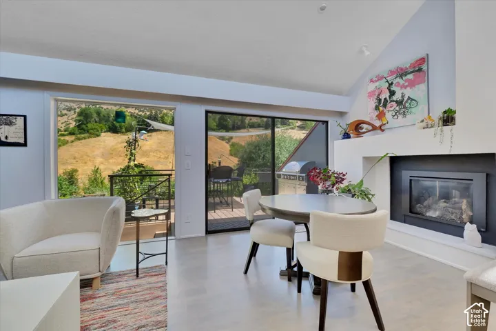 Bright living area featuring a vaulted ceiling and a built-in fireplace with a mantel