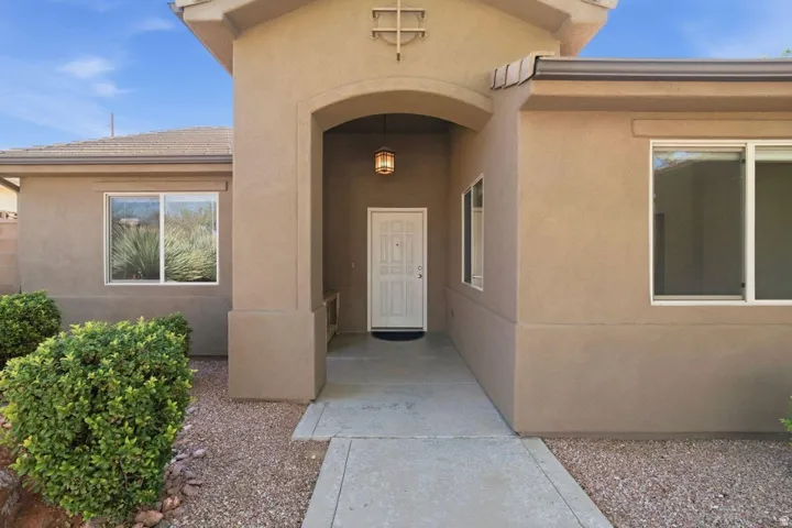 Inviting stucco exterior featuring a covered entryway with an overhead lantern fixture