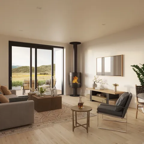 Spacious living area featuring light wood-finish flooring, a freestanding fireplace with a black flue, and large sliding glass doors opening to an outdoor patio