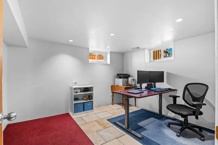 Versatile room featuring recessed lighting, a combination of square tile flooring and carpet, and two transom windows