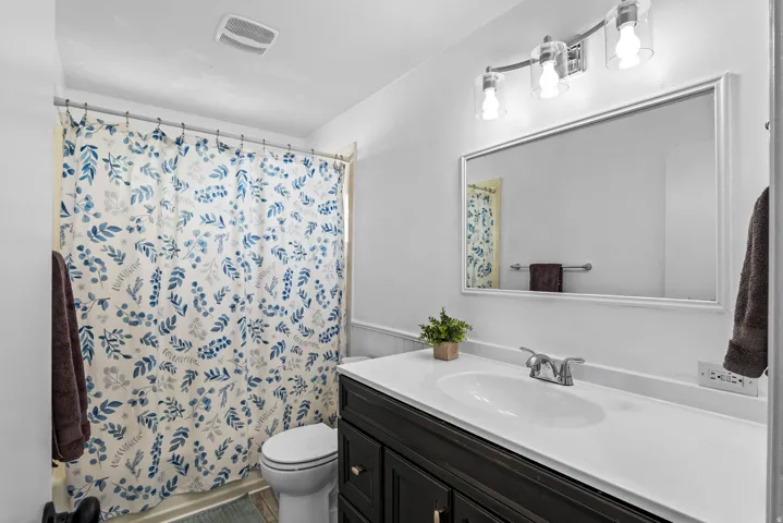 Bathroom featuring a dark wood-finish vanity with a white countertop and integrated sink