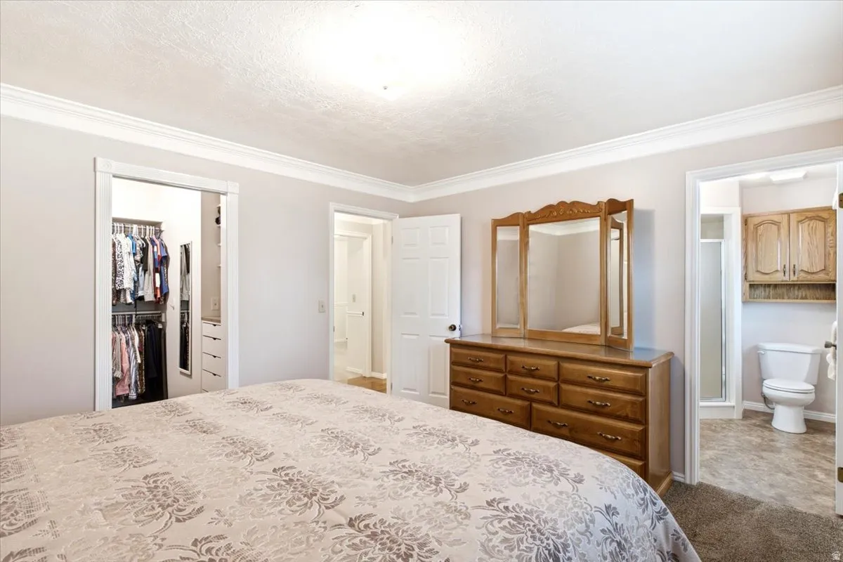 Primary bedroom suite with walk-in closet and en suite bathroom with granite countertops