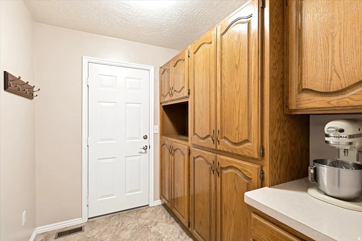 Butlers Pantry with handcrafted cabinetry, and area for appliances and extra kitchen items. Also utilized as entrance point from garage.