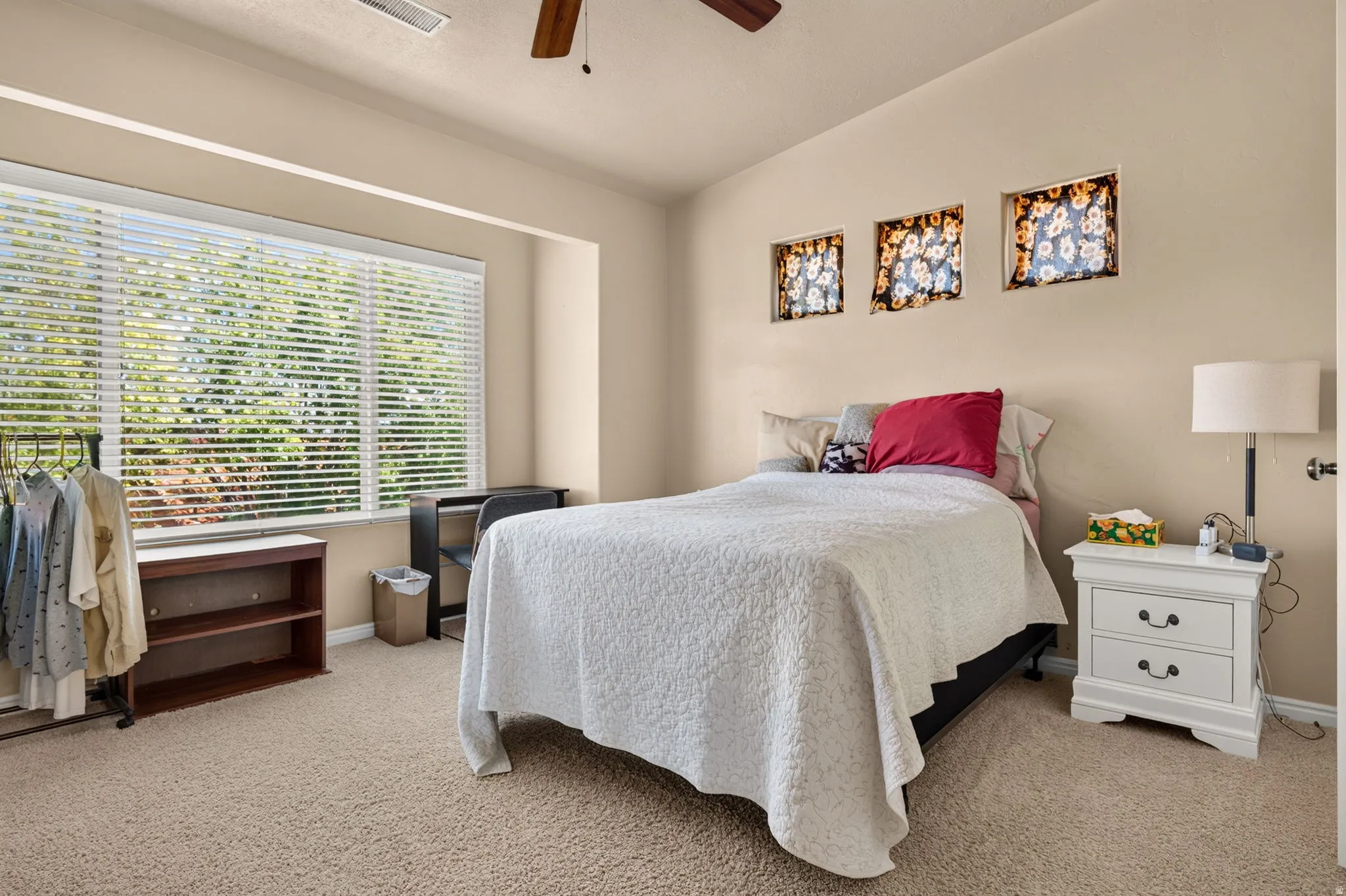 Spacious room featuring a large window with horizontal blinds, three decorative wall niches, a ceiling fan, and neutral-toned wall paint