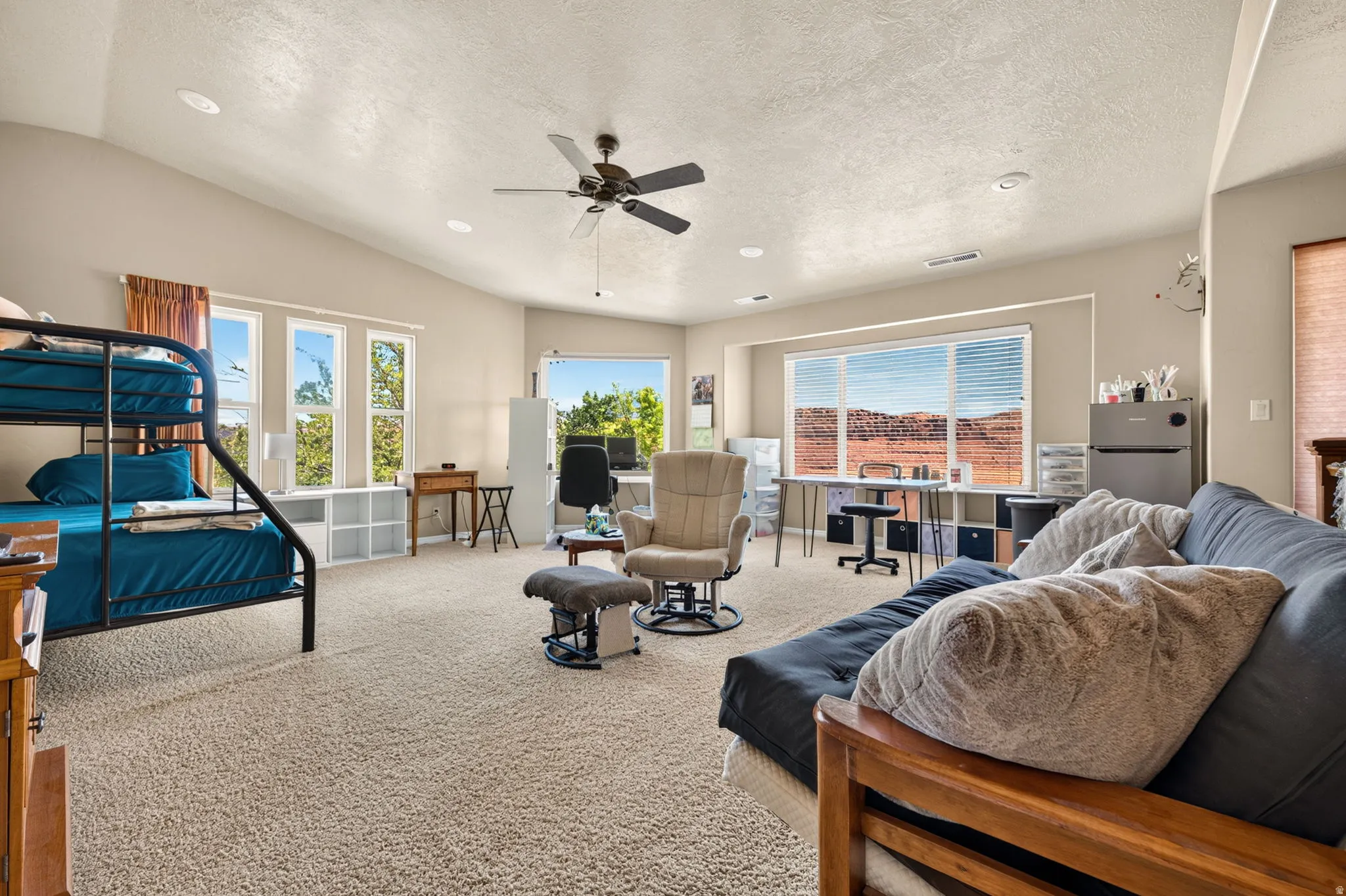 Spacious room featuring vaulted ceilings, recessed lighting, and a ceiling fan