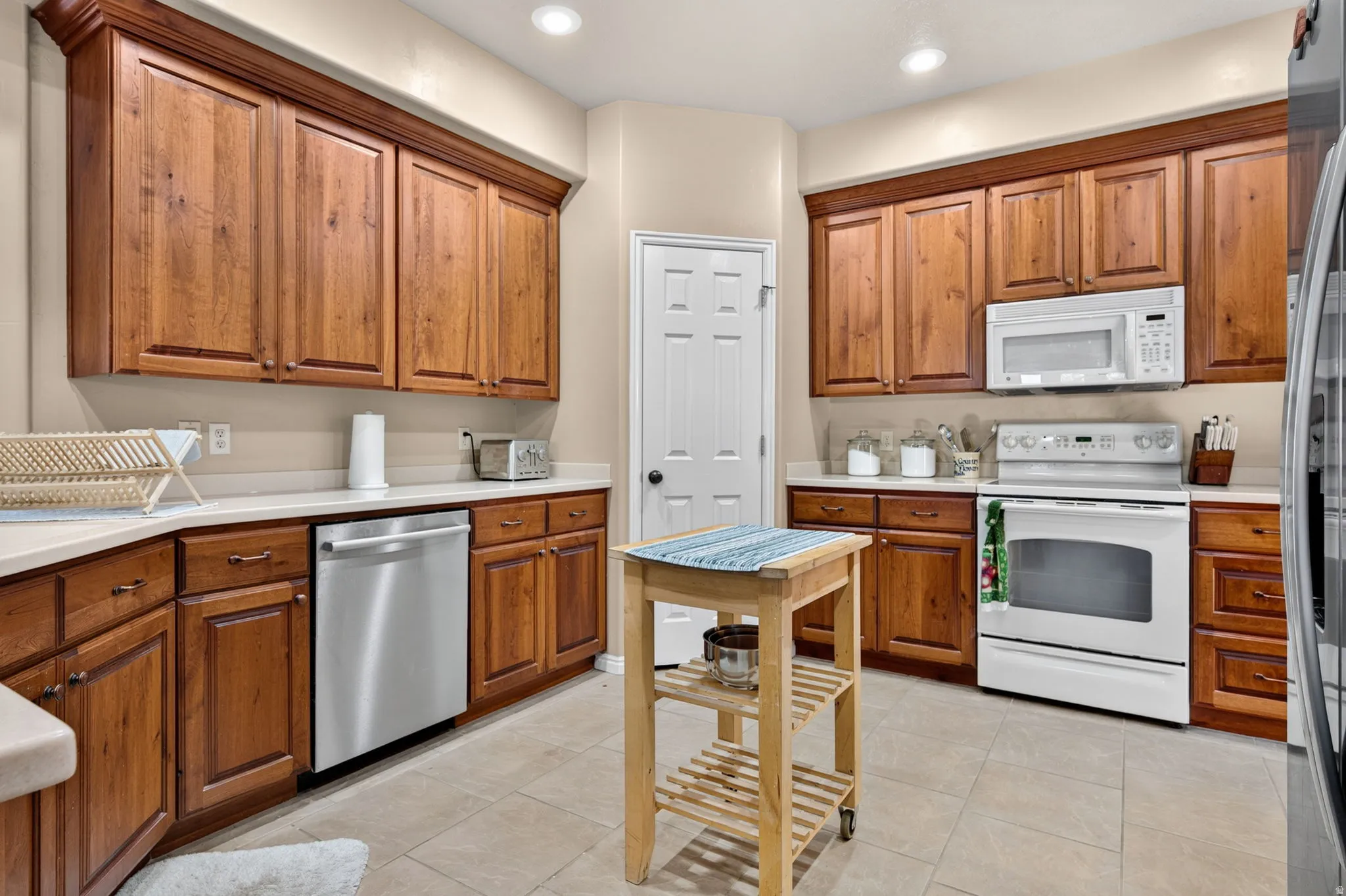 Kitchen featuring wood cabinetry, light countertops, and tile flooring