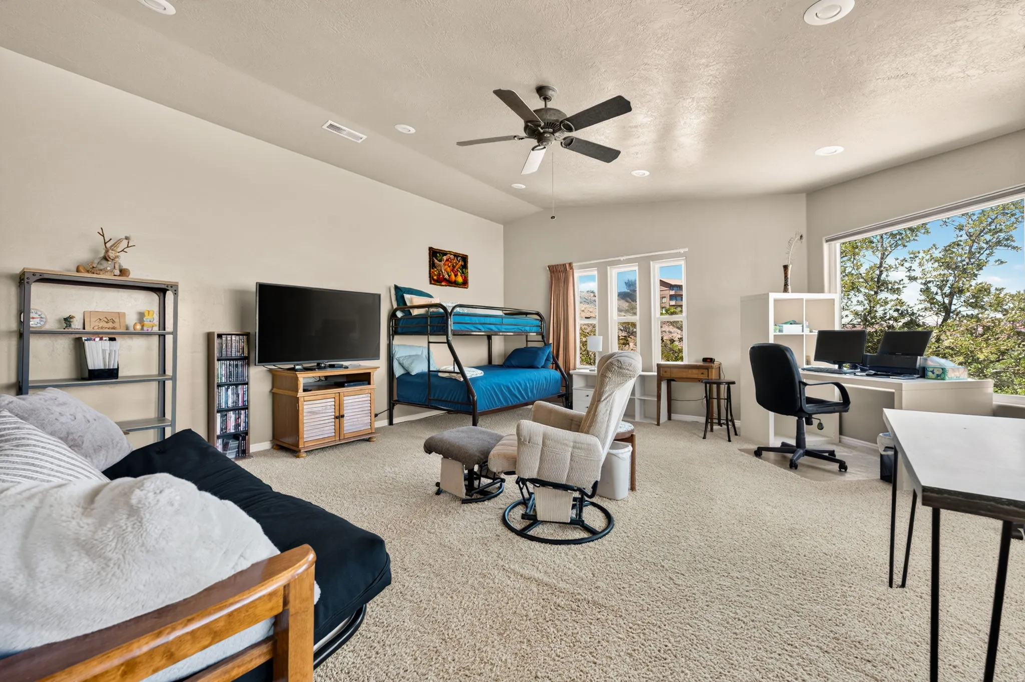 Spacious room featuring neutral carpeting, recessed lighting, and a ceiling fan