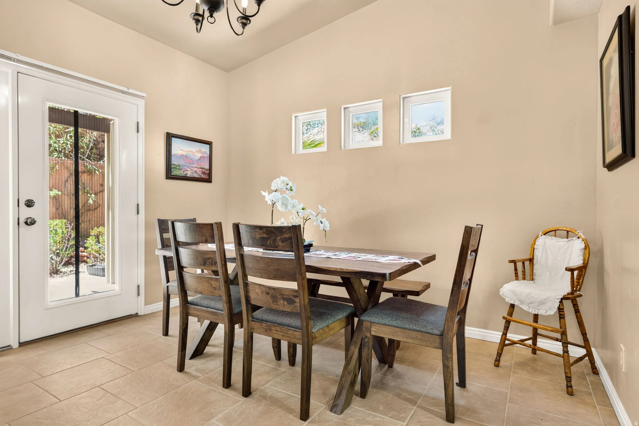Dining area featuring neutral wall tones, tile flooring, and a glass-paned exterior door