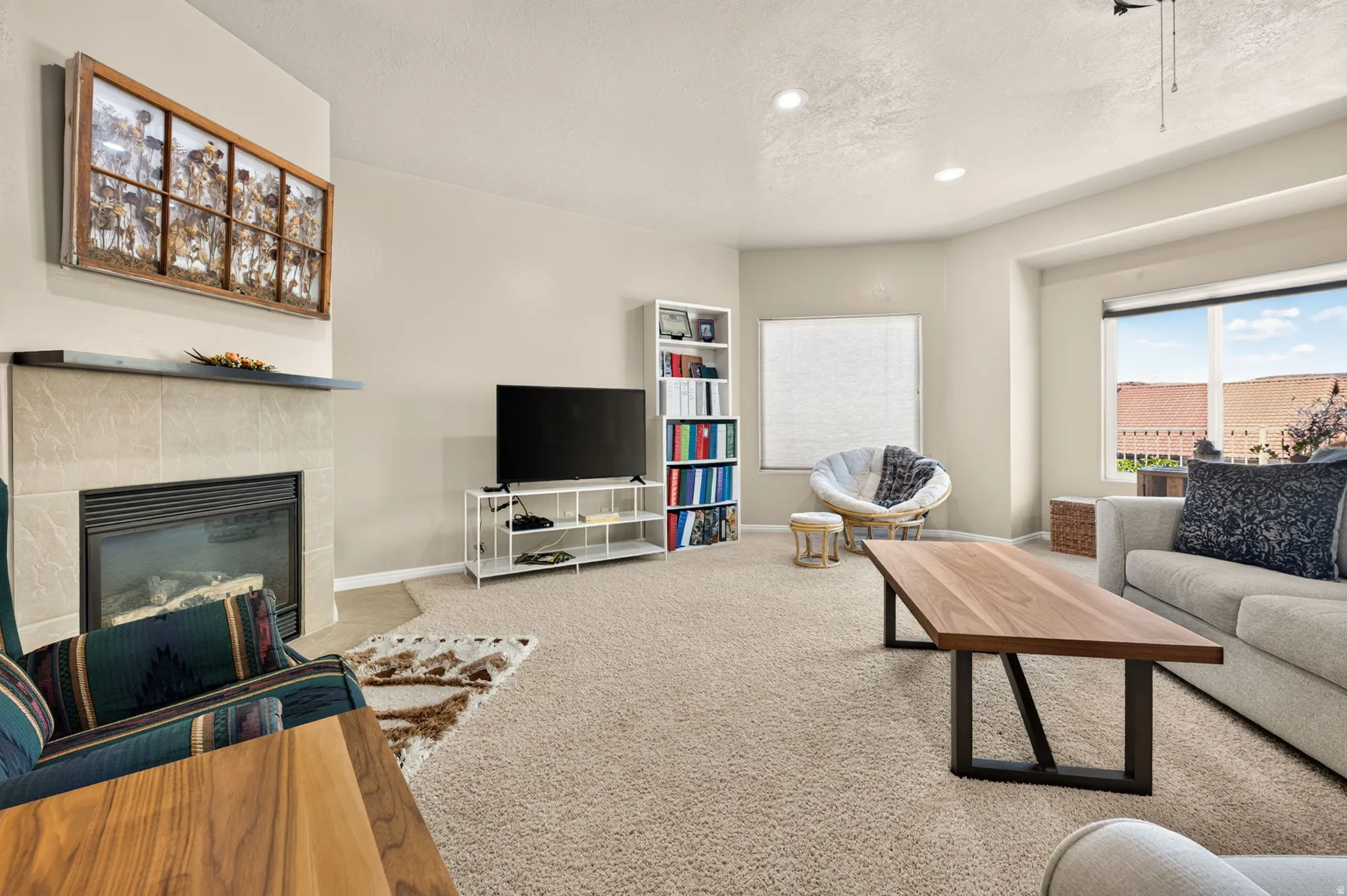Living area featuring recessed lighting, a fireplace with a tiled surround and dark mantel, and carpet flooring