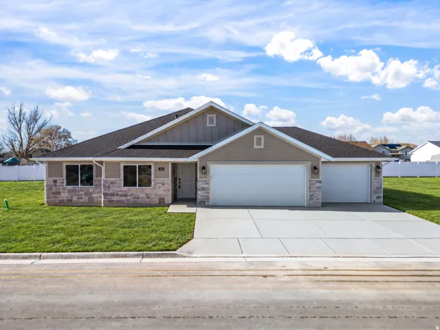Single-story residence featuring a combination of siding and stone veneer, a black shingled roof, a two-car garage, and a concrete driveway