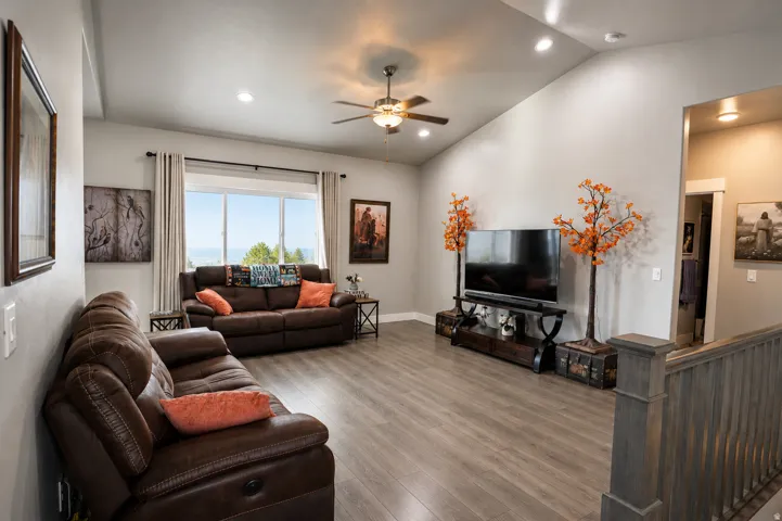 Spacious living area featuring vaulted ceilings, recessed lighting, and wood-finish flooring