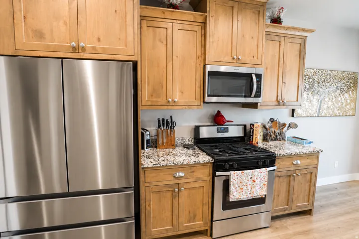 Kitchen featuring stainless steel appliances including a side-by-side refrigerator, gas range, and built-in microwave