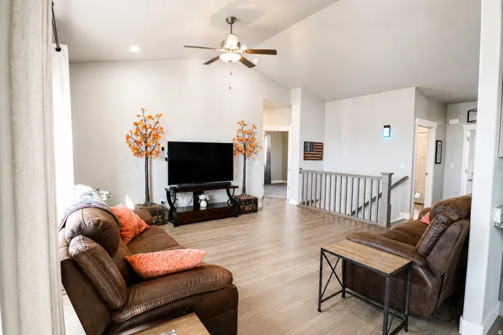 Expansive living area featuring vaulted ceilings, recessed lighting, and wood-finish flooring