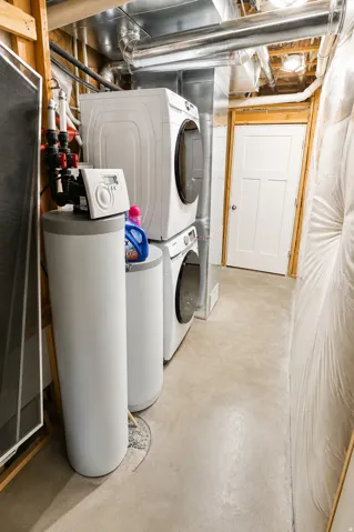 Dedicated laundry area featuring stacked front-load washer and dryer units