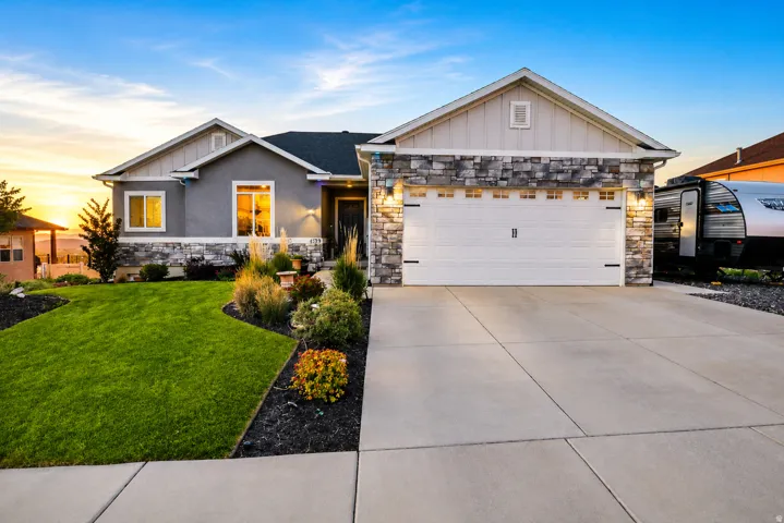 Modern ranch-style home featuring a stone veneer facade, stucco siding, and a gabled roofline