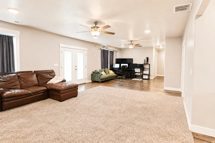 Spacious interior featuring a combination of carpet and wood-finish flooring, recessed lighting, and ceiling fans
