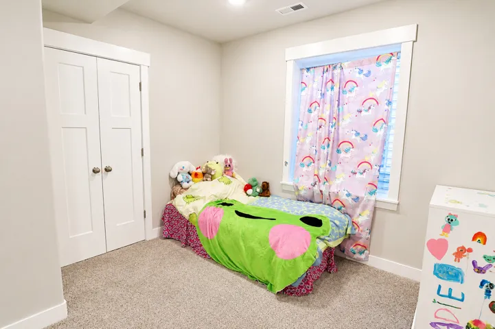 Carpeted room with a double-door closet featuring panel doors and round knobs