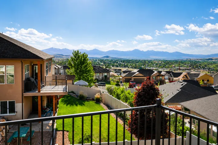 Two-story stucco residence with a multi-level deck and a tiered backyard