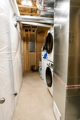 Laundry area featuring exposed ductwork, a floor drain, and a utility panel