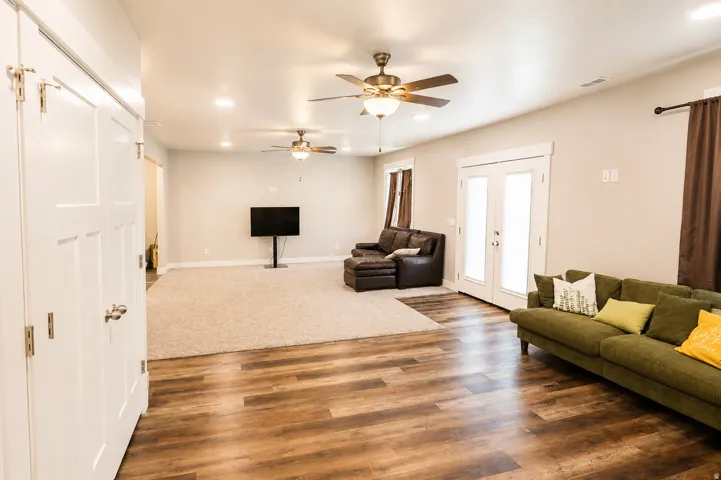 Spacious living area featuring wood-finish flooring and light-toned carpeting