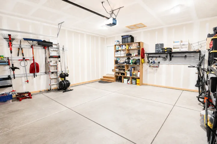 Spacious garage featuring a concrete floor, overhead lighting, and an automatic garage door opener