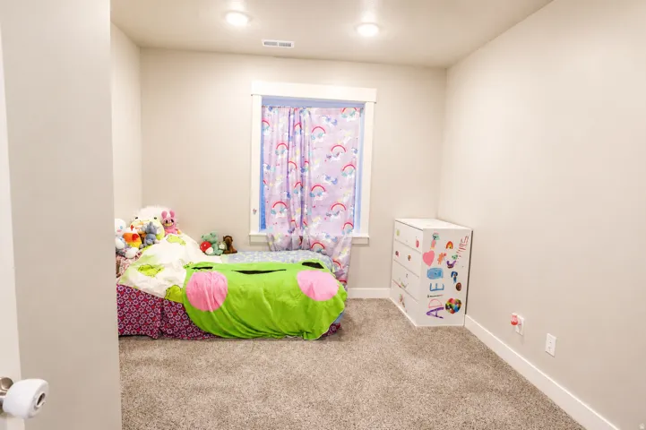 Bedroom featuring neutral wall paint, carpet flooring, a window with white trim, and recessed ceiling lighting