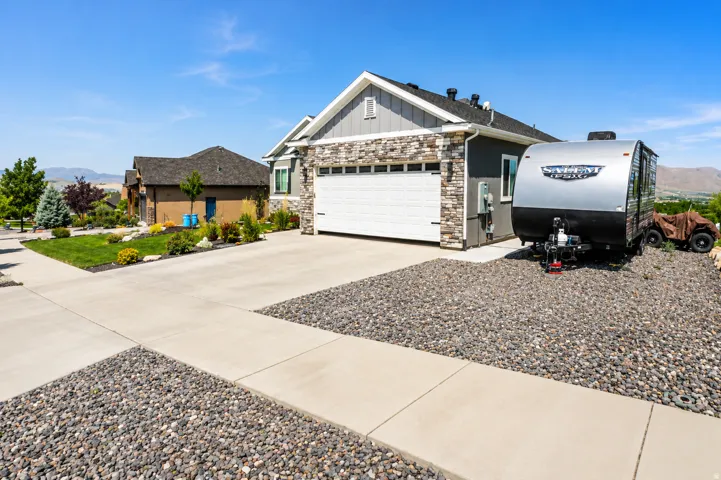 Contemporary single-story residence featuring a two-car garage, stone and siding exterior finishes, and a concrete driveway
