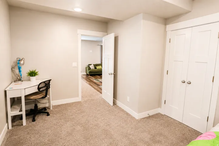 Carpeted room featuring light neutral wall tones, white baseboards, and a recessed ceiling light
