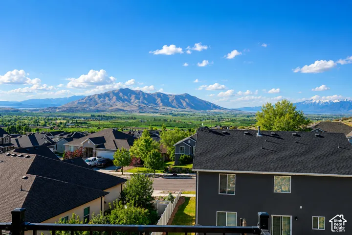 Expansive mountain range backdrop with distant snow-capped peaks and agricultural fields