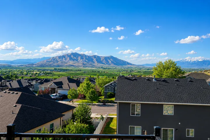 Expansive mountain range backdrop with distant snow-capped peaks and agricultural fields