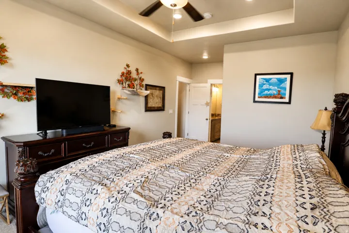 Room featuring a tray ceiling with recessed lighting and a ceiling fan
