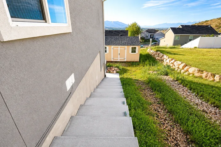 Concrete staircase descending from the stucco exterior