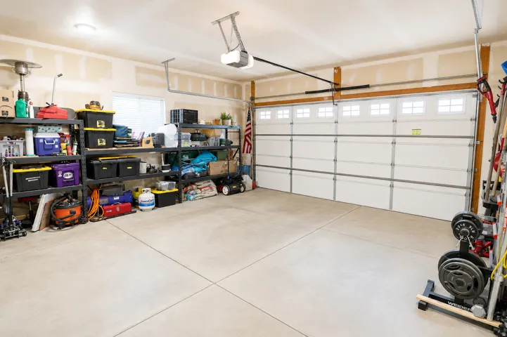 Spacious garage featuring a sectional overhead door with upper window panels and an automatic opener