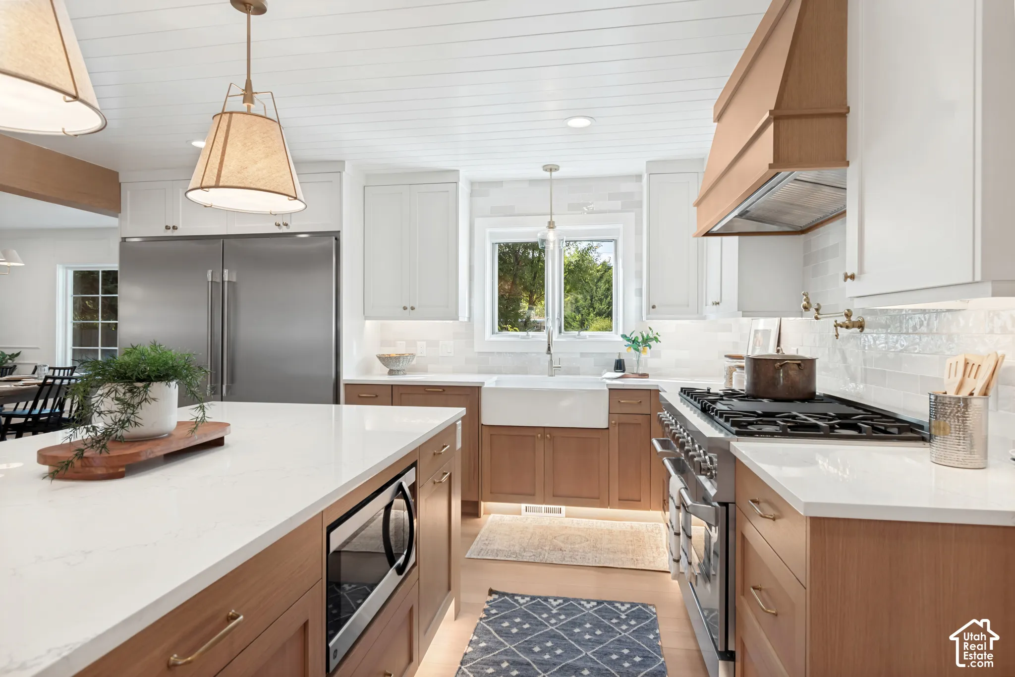 Kitchen featuring a white farmhouse sink, stainless steel appliances, and a wood-paneled ceiling