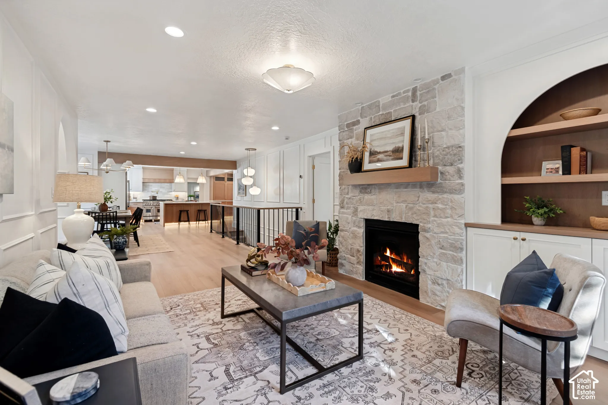 Living area featuring a stone fireplace with a wood mantle, recessed lighting, and wood-finish flooring