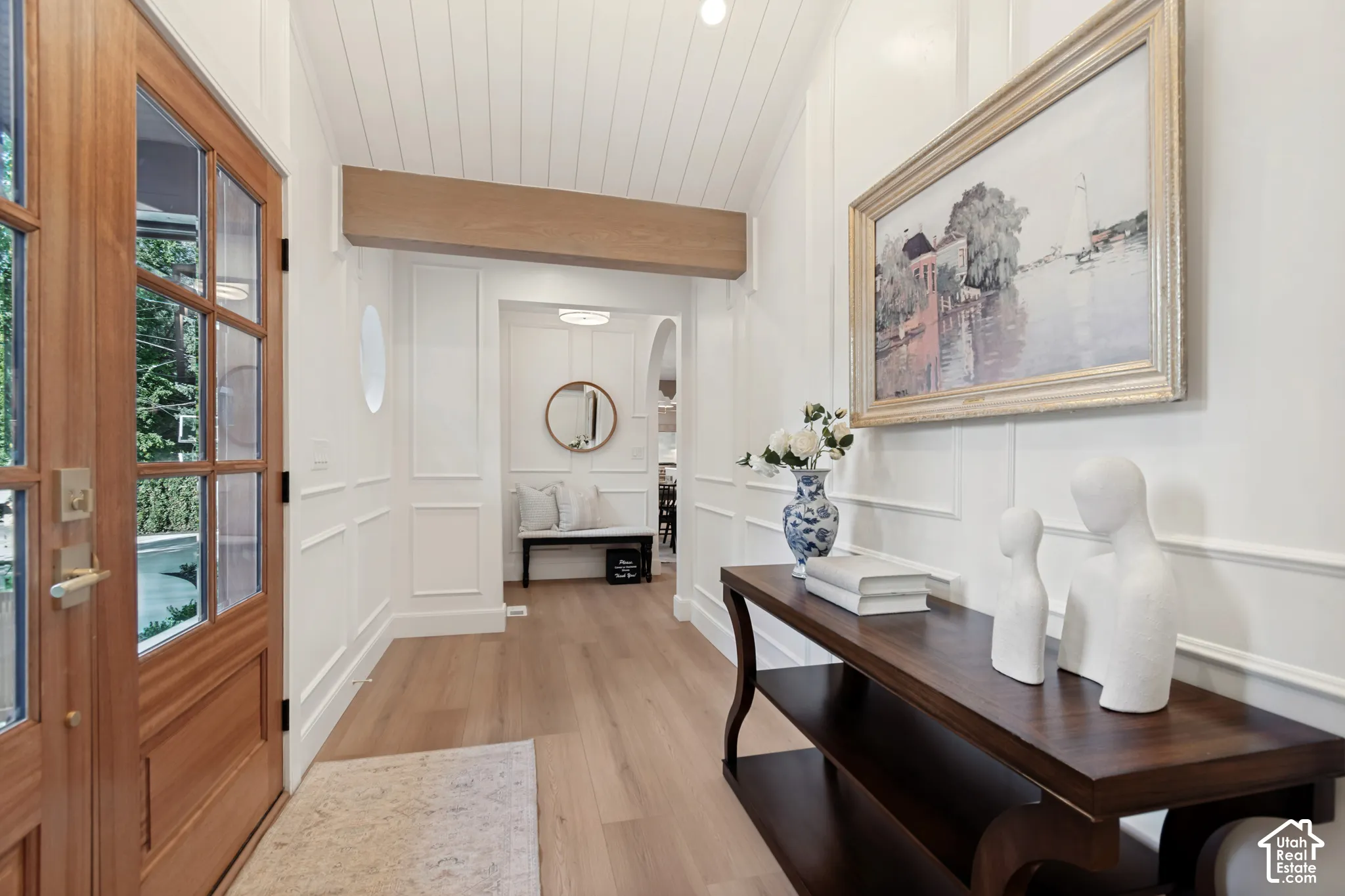 Entryway featuring a paneled wood-frame front door, light wood-finish flooring, white shiplap ceiling, and wainscoting