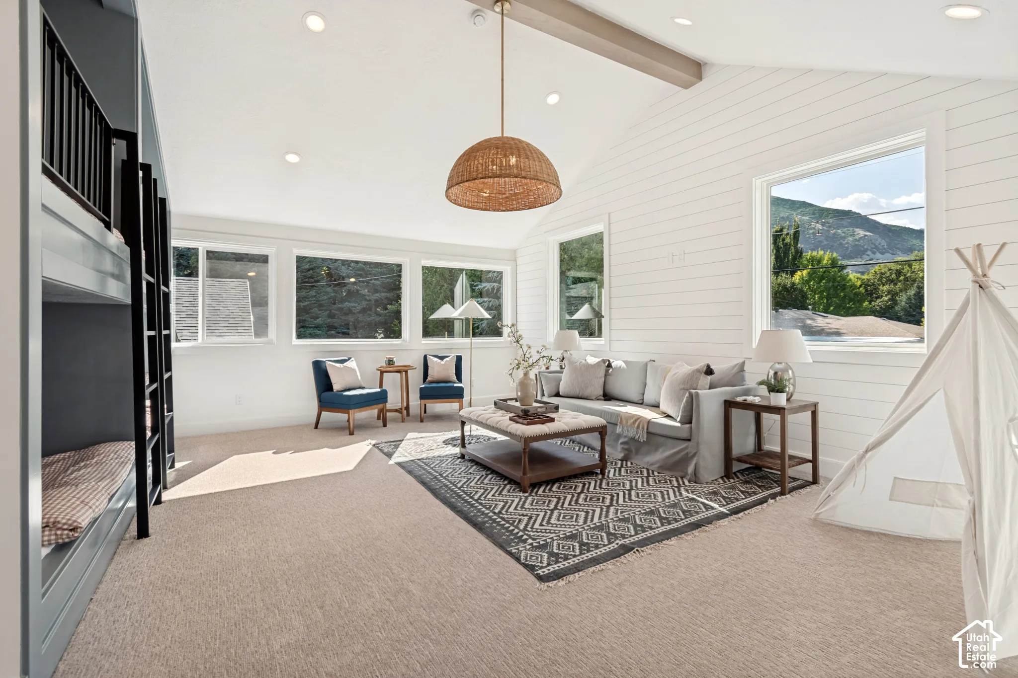 Spacious bonus room featuring vaulted ceilings with a wood beam accent, shiplap wall detailing, recessed lighting, and multiple large windows with mountain scenery