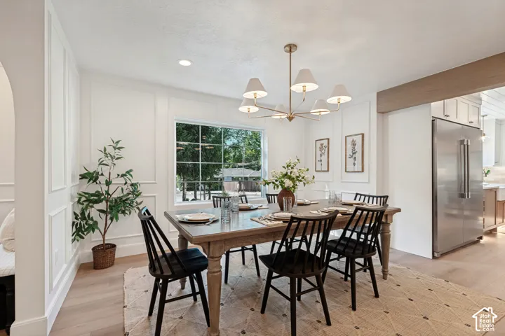 Dining space featuring wainscoting, wood-finish flooring, and a large window
