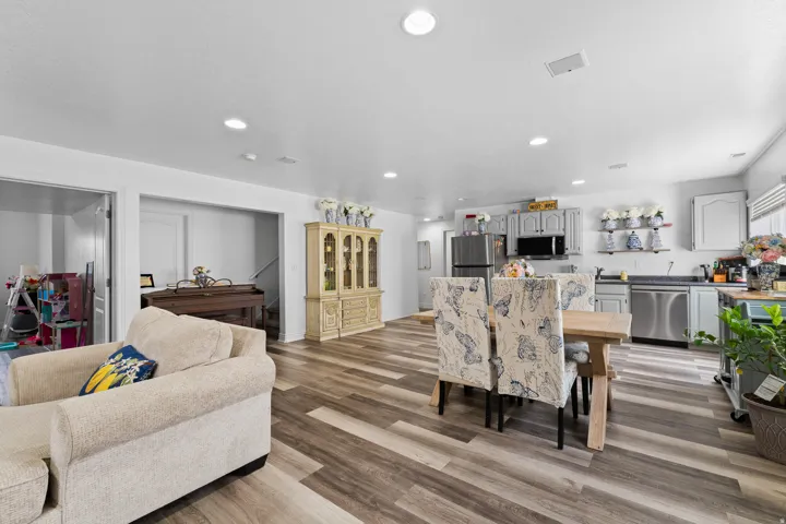 Open-concept living area featuring wood-finish flooring, recessed lighting, and a light-toned color palette