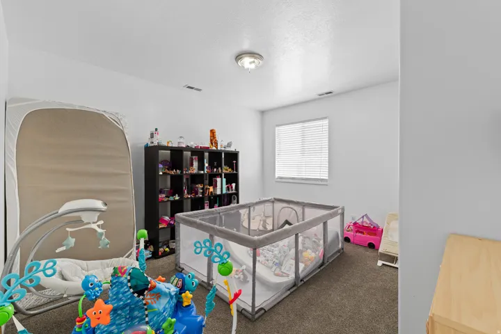 Room featuring light gray walls, a window with horizontal blinds, and a flush-mount ceiling light fixture