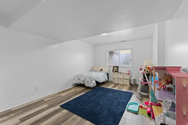 Interior room featuring wood-finish flooring, white baseboards, and neutral wall paint