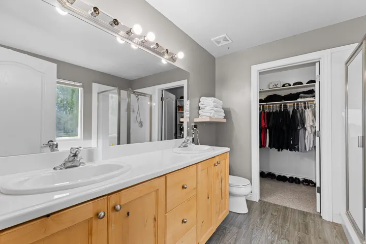 Double vanity with light wood-finish cabinetry and white countertops