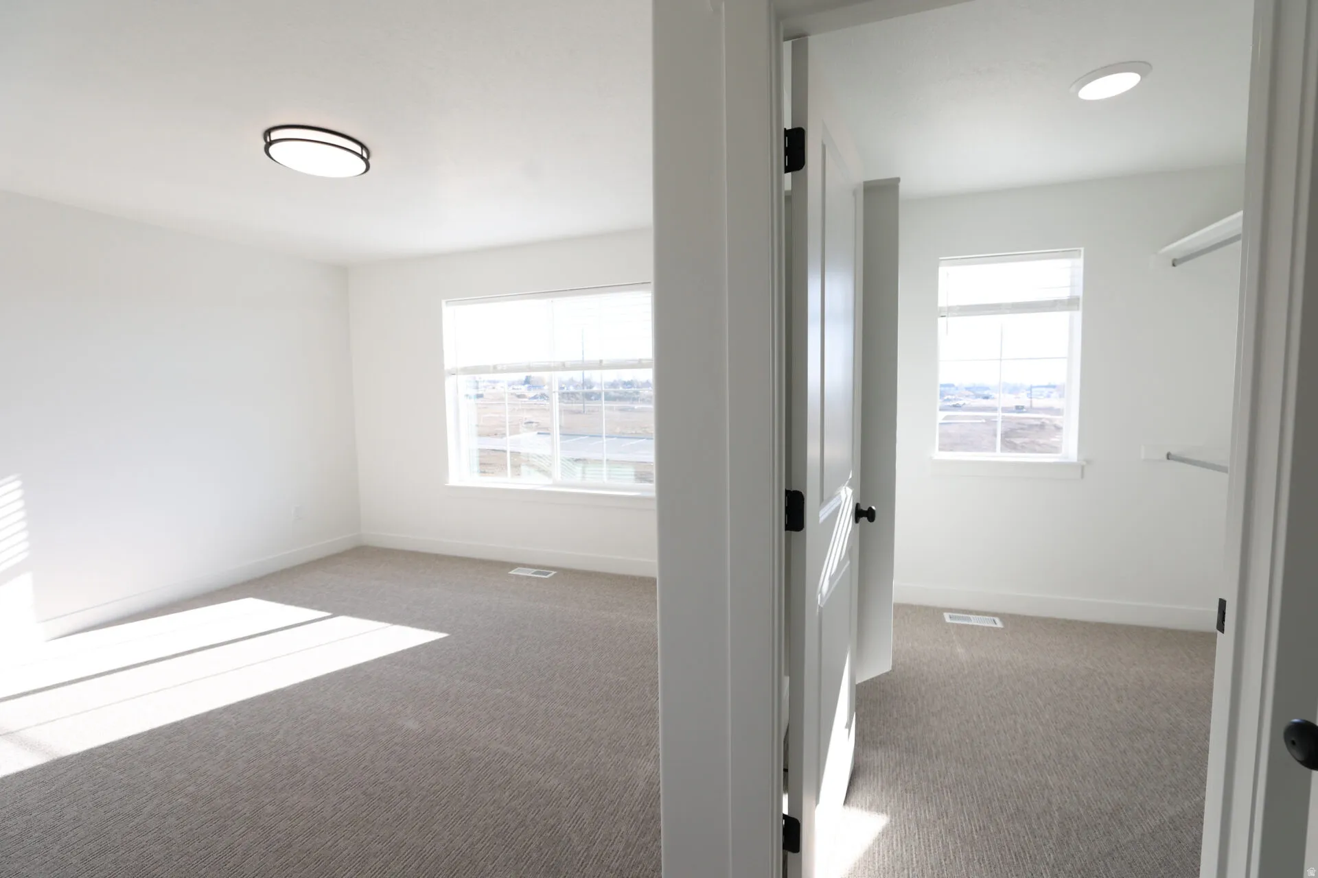 Spacious room with light neutral carpet and white walls