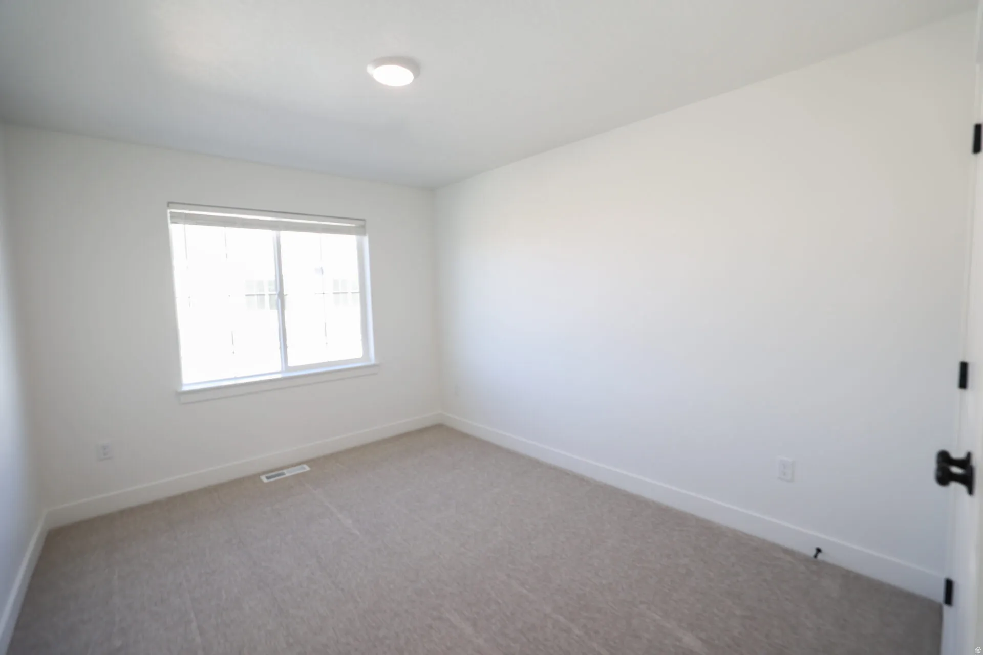 Neutral tone carpeting and white walls in a bright interior space
