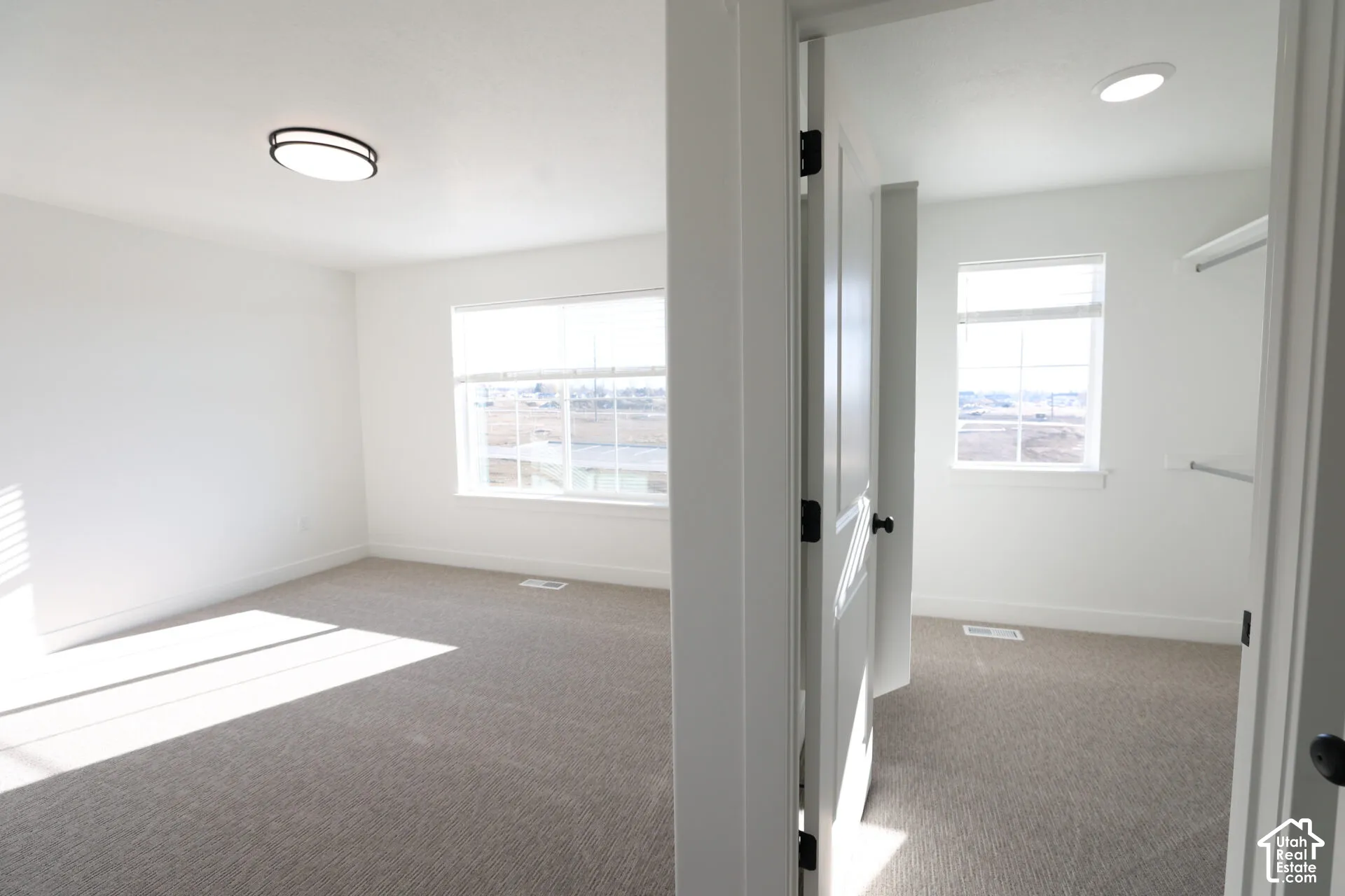 Spacious room with light neutral carpet and white walls