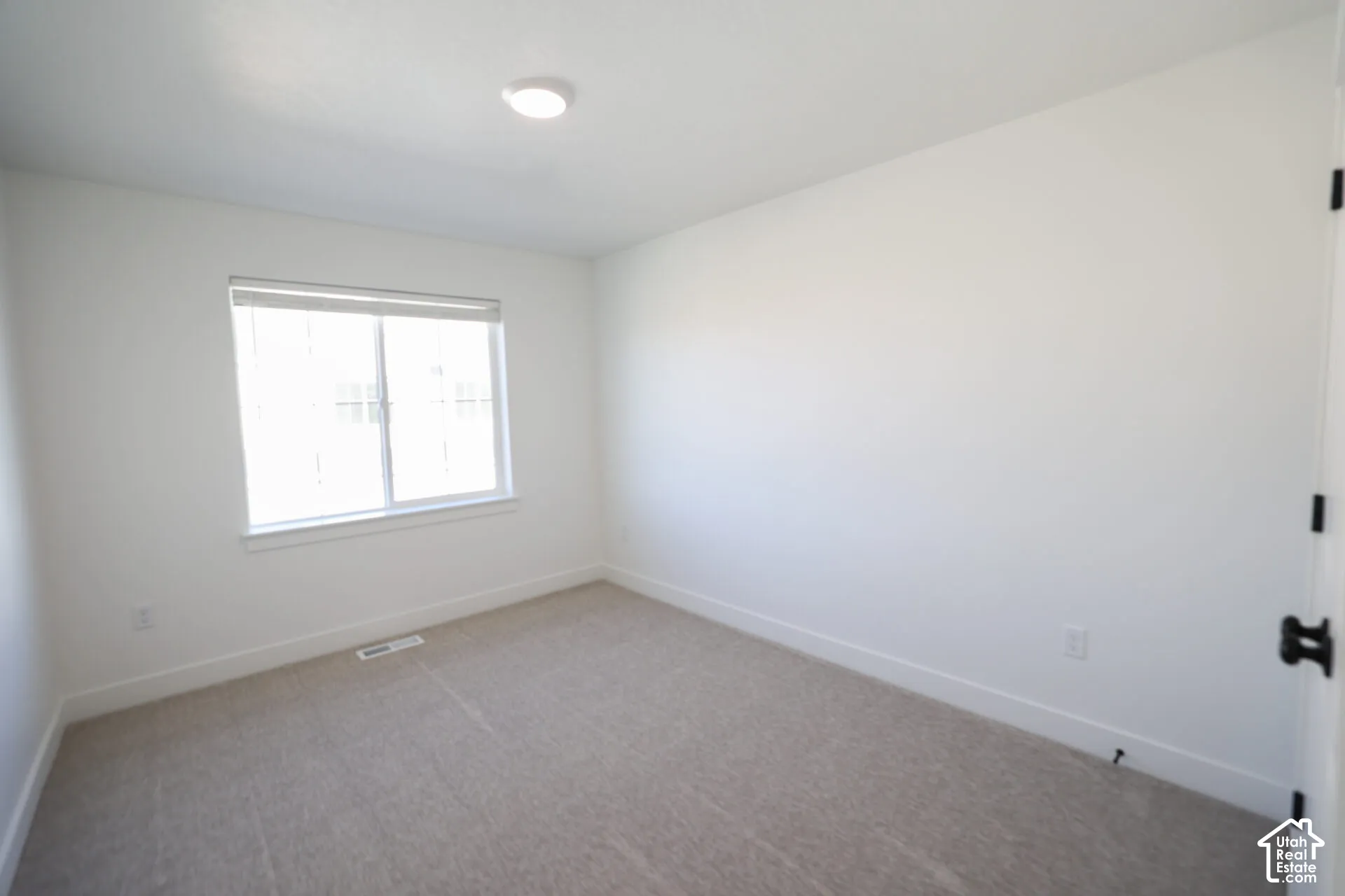Neutral tone carpeting and white walls in a bright interior space