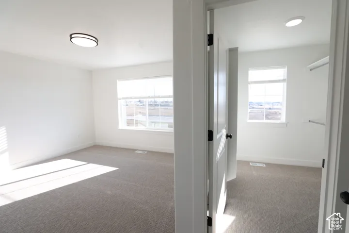 Spacious room with light neutral carpet and white walls