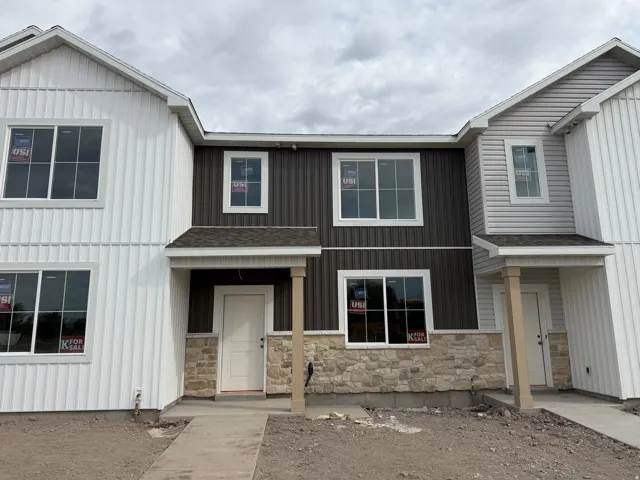 Multi-level exterior featuring vertical siding, horizontal siding, stone veneer accents, and a covered entryway