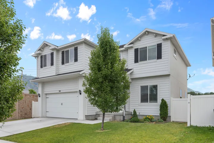 Two-story residence featuring light gray siding with black window shutters